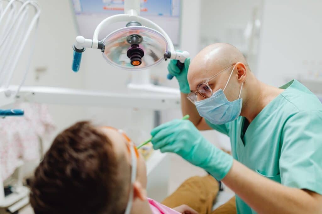 Chirurgien-dentiste en train de soigner une patiente au fauteuil