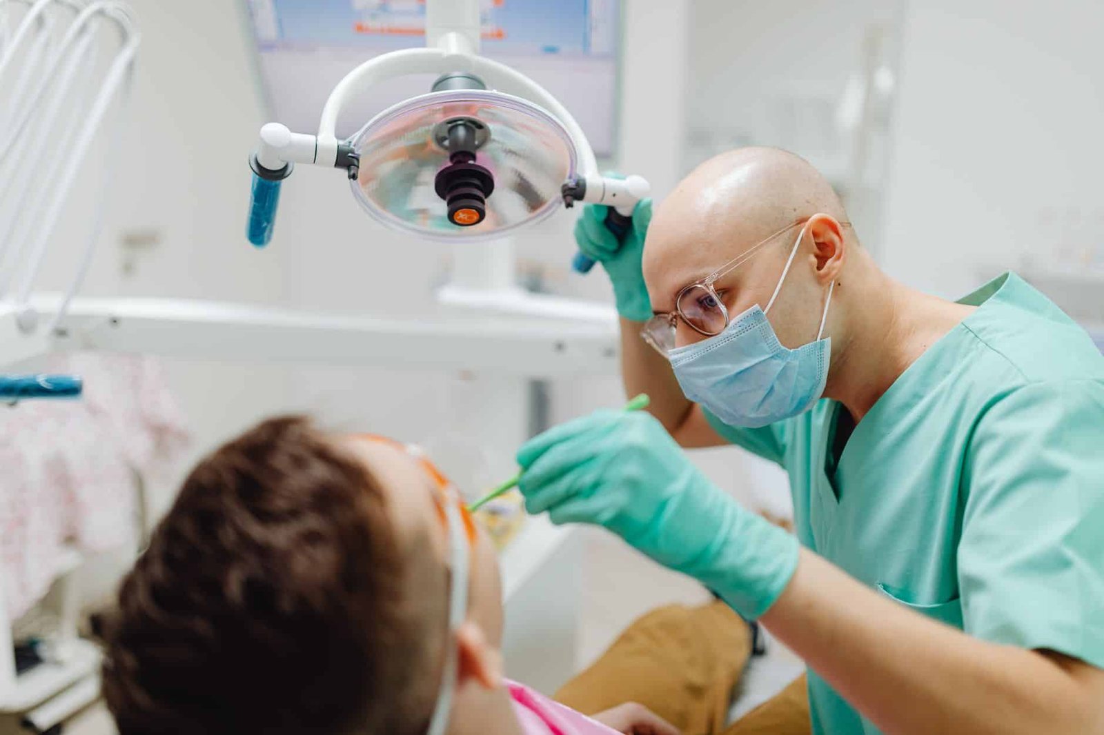 Chirurgien-dentiste en train de soigner une patiente au fauteuil