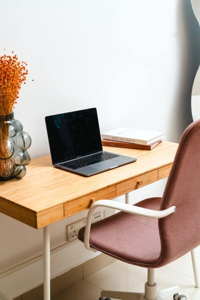 Bureau épuré et lumineux avec ordinateur portable et carnet, évoquant le cabinet calme d'un psychologue libéral.