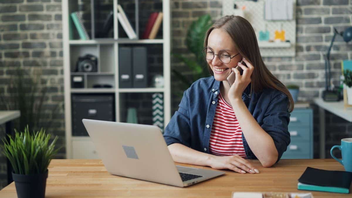 Professionnelle souriante au téléphone, accueil téléphonique des patients