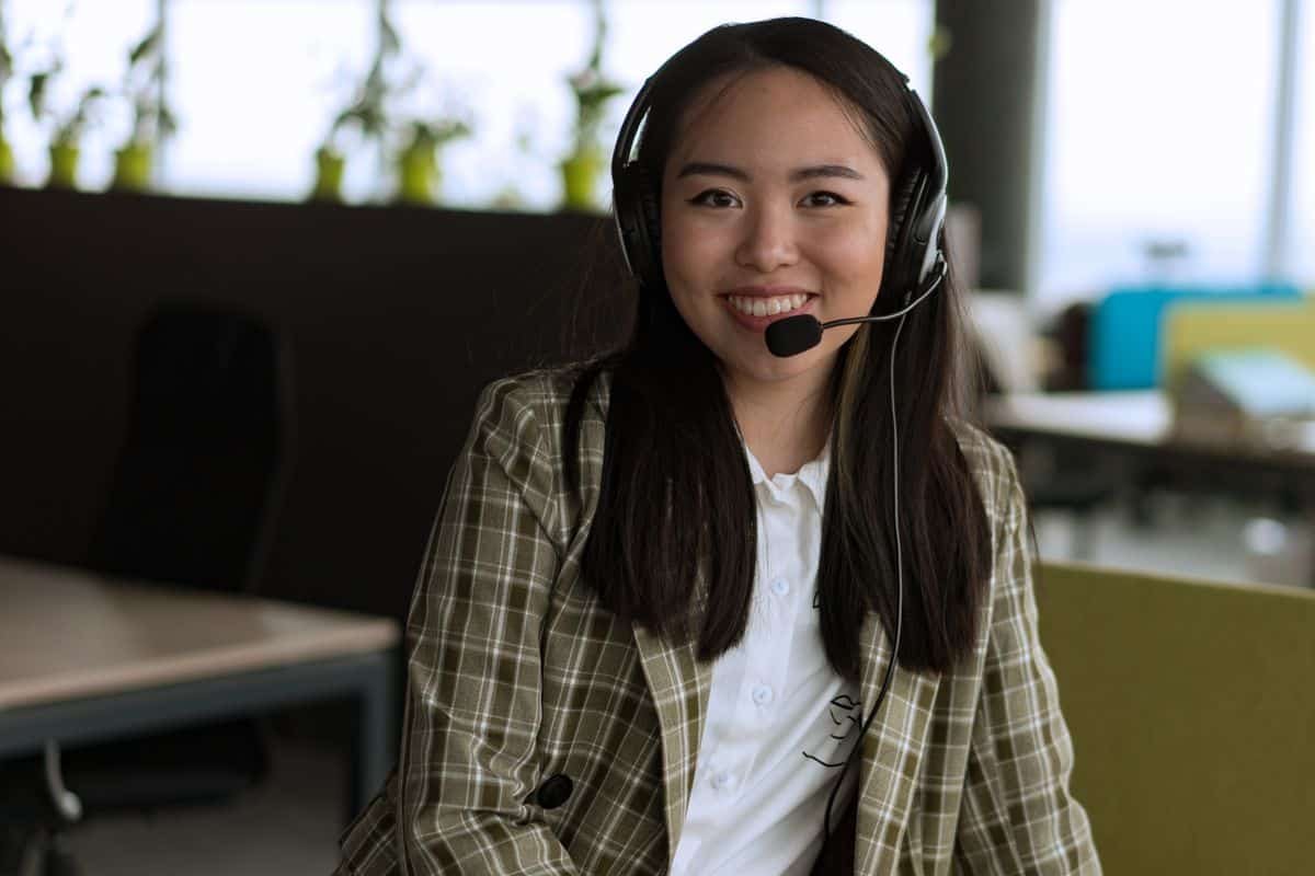 Secrétaire médicale souriante au casque assurant l'accueil téléphonique d'un cabinet de psychologie